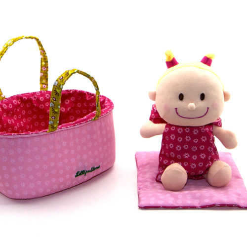 Bébé Chloé est couché confortablement dans son petit couffin douillet, en-dessous de sa couverture. Au réveil, on change le lange. C’est tellement chouette d’être bébé. Le lange et le pyjama sont faciles à enlever et remettre pour des petites mains.